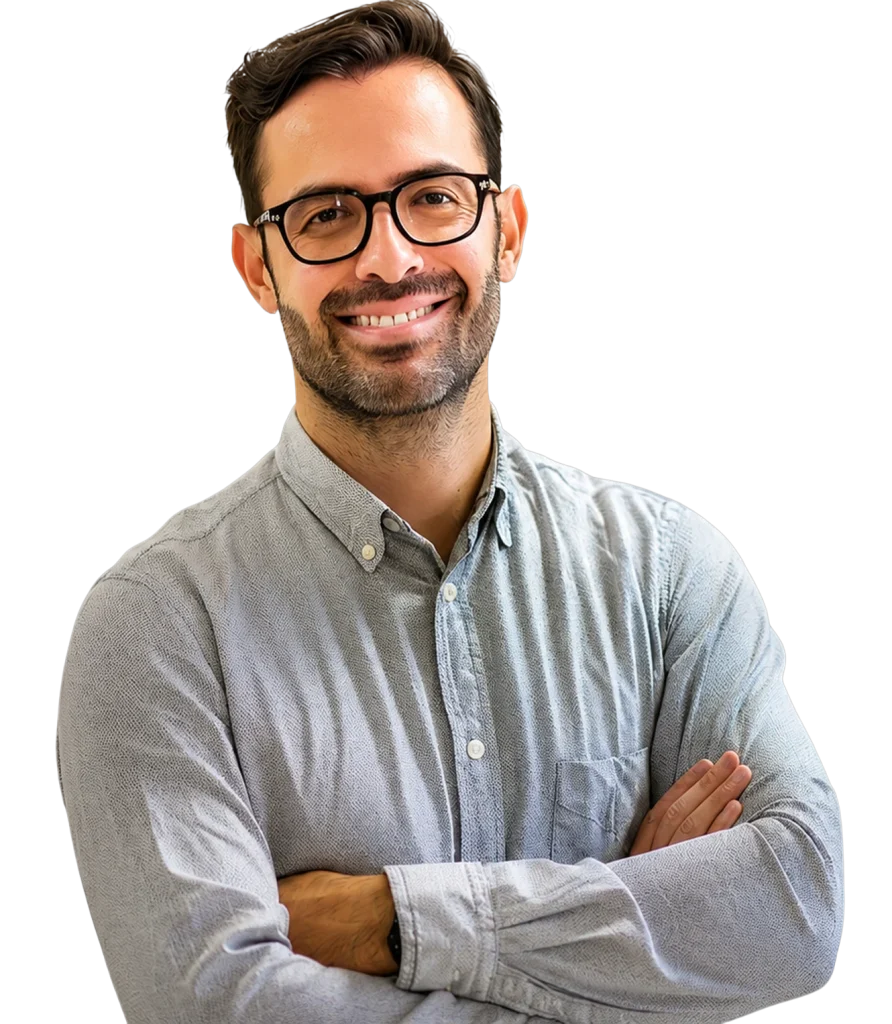 Docente sonriente con gafas y camisa gris, brazos cruzados